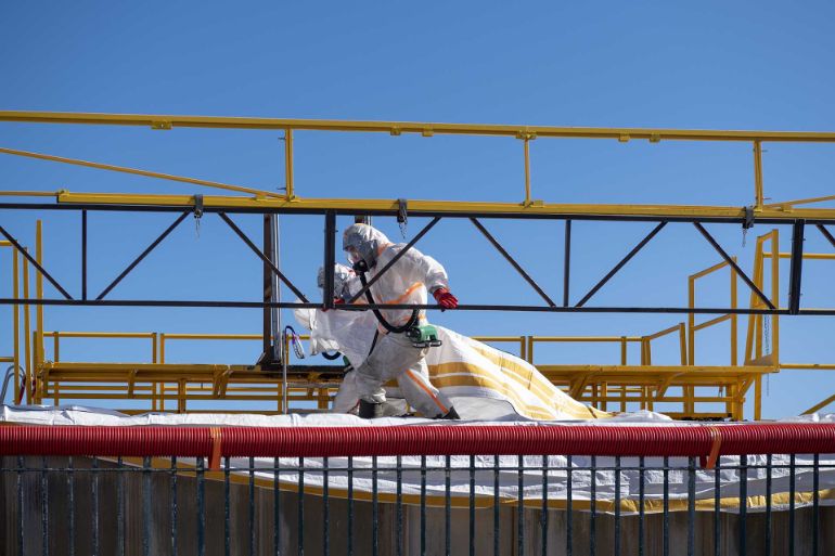 Des opérateurs ferment les conteneurs-bags contenant l'amiante