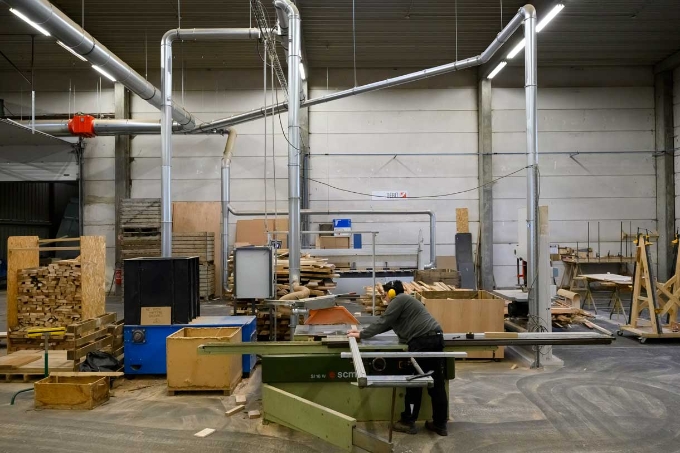 Un salarié de la menuiserie utilise une machine à découpe. Un salarié de la menuiserie utilise une machine à découpe.