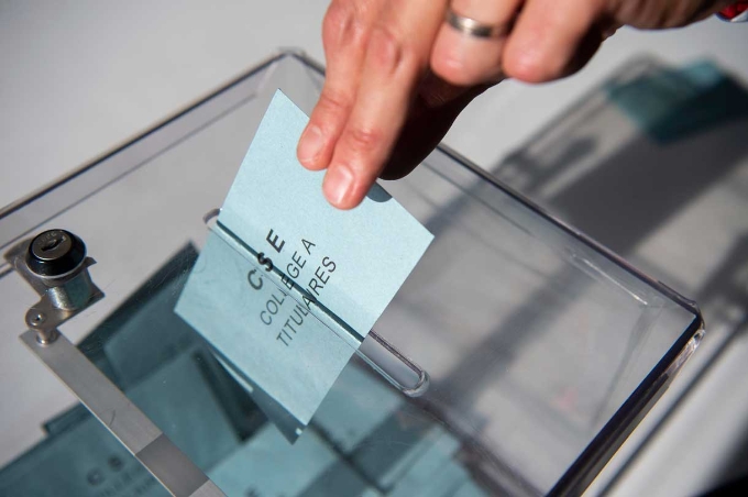 Un salarié met un bulletin de vote dans une urne lors d'une élection CSE.
