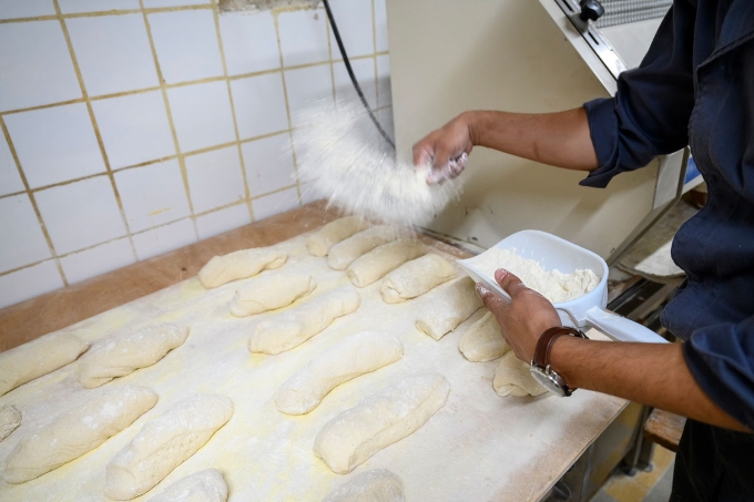 Un boulanger prépare des baguettes de pain.