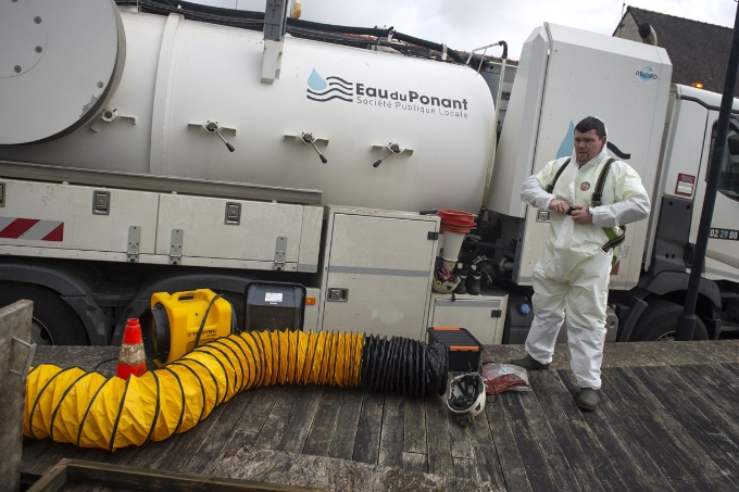 Un salarié de l'entreprise Eau du Ponant s'équipe d'une combinaison.