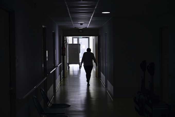 Vue d'une personne marchant dans un couloir sombre.