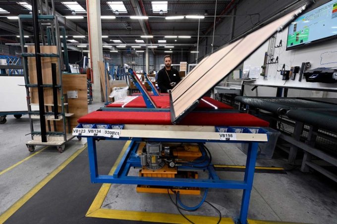 Les quatre bras de l'Ergotable permettent de soulever la porte en cours d'assemblage, de la retourner, de la faire tourner puis de la glisser vers le convoyeur qui l'amène au contrôle qualité.