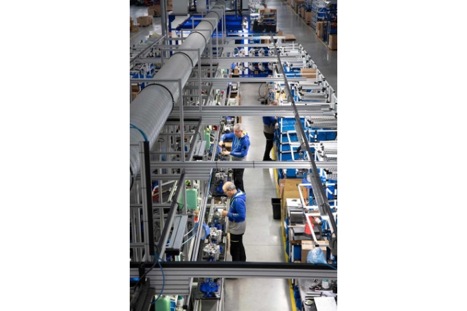 Les lignes d'assemblage sont traversées par des convoyeurs. L'éclairage a été optimisé pour ce travail minutieux,  les opérateurs ont tout à portée de main dans des bacs bleus et les outils sont dotés d'équilibreurs.